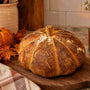 Pumpkin Sourdough Bread in a cozy kitchen with fall decor and a candle